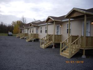 una fila de casas modulares estacionadas en un estacionamiento en Lakeview Motel & Apartments en Massena