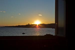 a sunset view from a window of a lake at Oasis in Acitrezza