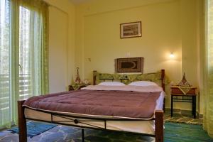 a bedroom with a bed in a room with a window at Evaland Traditional Houses in Tarti +33 photos