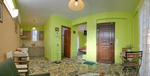 a kitchen with green walls and a wooden door at Evaland Traditional Houses in Tarti