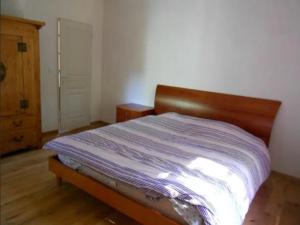 - une chambre avec un lit doté d'une tête de lit en bois dans l'établissement Mas Ferrieres Saint Laurent, à Saint-Laurent-le-Minier