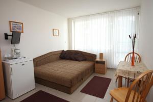 uma sala de estar com um sofá e uma mesa em Siesta Apartmanház Balatonfüred em Balatonfüred