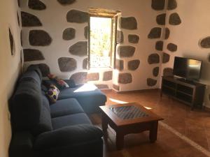 聖巴托洛梅的住宿－COUNTRY HOUSE MIS ABUELOS TAIDIA，带沙发、桌子和窗户的客厅