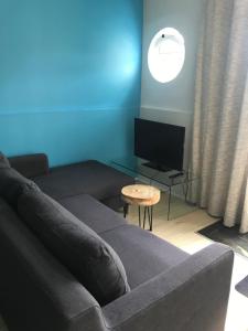 a living room with a couch and a tv at Quartos do Seixe - Azul in Odeceixe
