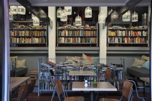 a library with tables and chairs and books at Hotel Credible in Nijmegen