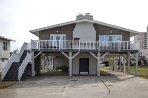 a house with a deck and stairs on it at Latitude Adjustment in Myrtle Beach