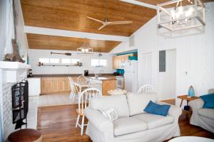 a living room with a white couch and a kitchen at Latitude Adjustment in Myrtle Beach