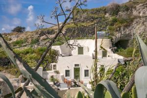 a white house on the side of a mountain at Agrilia secluded cave house in Thirasia