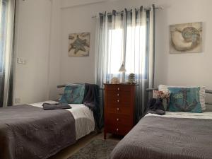 a bedroom with two beds and a dresser and a window at Harmonia Blue in Polis Chrysochous +48 photos