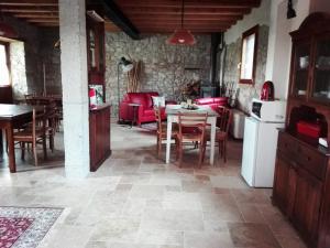 a kitchen and living room with a table and chairs at Casa della Fornace in San Vito al Torre