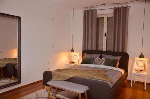 a bedroom with a large bed and a mirror at City Centre Apartment 2 in Shkodër