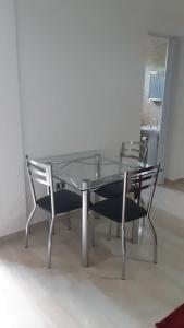 a glass table and chairs in a room at Apartamento Aconchegante em Foz in Foz do Iguaçu