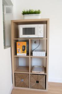 a book shelf with a microwave and some boxes at KASANZAS in Fuentespina