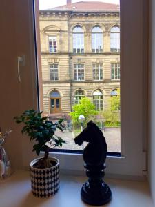 a cat statue sitting on a window sill next to a plant at Altbauwohnung im Herzen von Karlsruhe in Karlsruhe