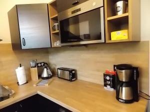 um balcão de cozinha com comodidades para preparar café e um micro-ondas em Les Gîtes De Morville em Malaumont