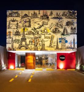 a building with a mural of the eiffel tower at Zuza Slim Suítes in Maceió