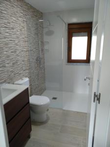 uma casa de banho com um chuveiro, um WC e um lavatório. em O CORPIÑO DE CHORENTE em Muxia