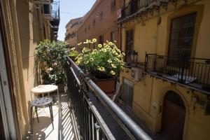 an apartment balcony with tables and plants on it at Hello World in Agrigento