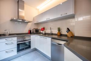 a kitchen with white cabinets and stainless steel appliances at Lux Apartments Barcelona in Barcelona