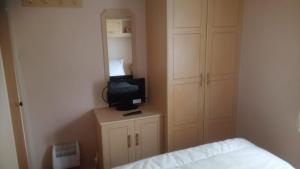 um quarto com uma cama e uma televisão num armário em TP52 em Skegness
