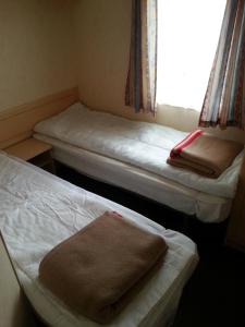 Duas camas num pequeno quarto com uma janela em TP52 em Skegness