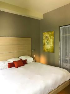 a bedroom with a bed and a lamp at CityFlatsHotel Grand Rapids in Grand Rapids