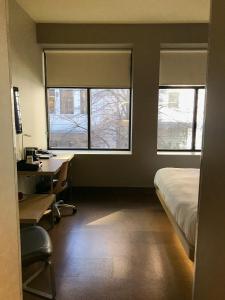a bedroom with a bed and a window at CityFlatsHotel Grand Rapids in Grand Rapids