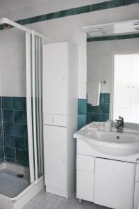 uma casa de banho branca com um lavatório e um chuveiro em Saint Jean de Luz & Beach by walk em Ciboure