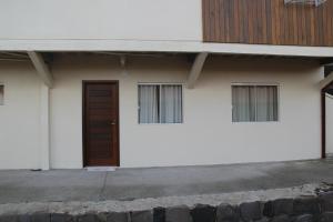 un edificio bianco con una porta e due finestre di Apartamento Serrano a São Joaquim