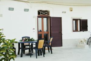 a table and chairs in front of a building at Casa sullo scoglio in Villanova di Ostuni