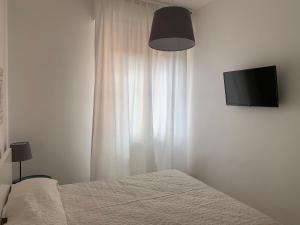 Un dormitorio con una cama y un televisor de pantalla plana. en Civico 3, en Sassari