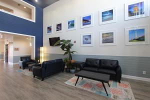 a waiting room with couches and pictures on the wall at Hotel Pensacola in Pensacola