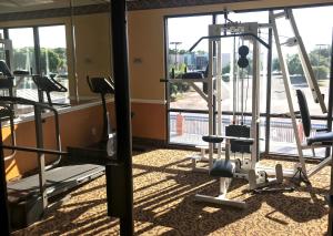 een fitnessruimte met verschillende loopbanden en een raam bij Hotel Pensacola in Pensacola
