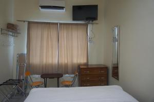 um quarto de hospital com uma cama e uma cómoda e uma janela em Woodbrook on the Avenue em Port of Spain