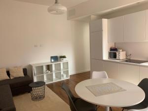 Una cocina y una sala de estar con mesa y sillas. en Civico 3, en Sassari