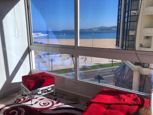 a bedroom with a large window with a view of a beach at la baie de Tanger in Tangier