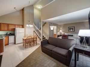 ein Wohnzimmer und eine Küche mit einem Sofa und einem Tisch in der Unterkunft Eastland Suites Extended Stay Hotel & Conference Center Urbana in Champaign