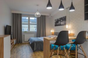 クラクフにあるNative Apartments Augustiańska 24のベッドルーム1室(ベッド1台、デスク、椅子2脚付)