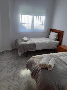 - une chambre avec 2 lits et des serviettes dans l'établissement Villa Noelia Benalmadena, à Benalmádena