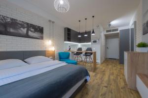 a bedroom with a large bed and a kitchen at Native Apartments Augustiańska 24 in Krakow