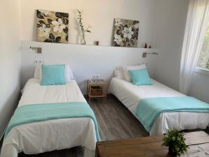 two beds in a room with white and blue at El Rincón de Cristina in Torre de Benagalbón