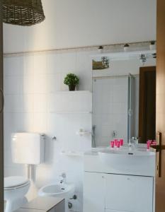 een witte badkamer met een toilet en een wastafel bij PIANA112 apartment in Cannobio +25 foto's
