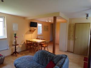 a living room with a couch and a dining room table at Ferienwohnung Magdalena in Hohnstein +10 photos