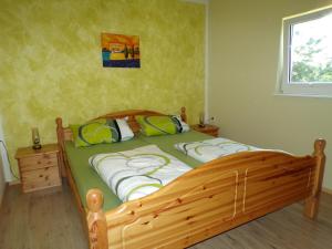 ein Schlafzimmer mit einem Holzbett und einem Fenster in der Unterkunft Ferienwohnung Magdalena in Hohnstein