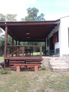 un pabellón de madera con mesa de picnic frente a un edificio en Casa de Campo Udea en Agua de Oro