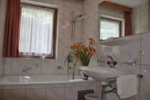 un bagno con un lavandino, una vasca da bagno e un lavandino di Hotel Kleon a Vent