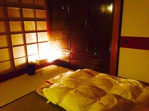 an unmade bed in a room with a light at Ise Chitose in Ise