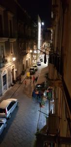 una strada di città di notte con auto parcheggiate sulla strada di Manganelli Home a Catania