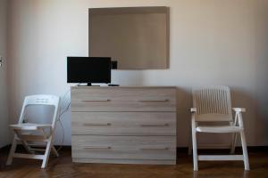グロッタンマーレにあるCasa Crociのベッドルーム1室(椅子2脚、ドレッサー、テレビ付)