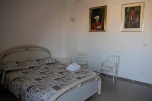 グロッタンマーレにあるCasa Crociのベッドルーム1室(ベッド1台、椅子、絵画付)